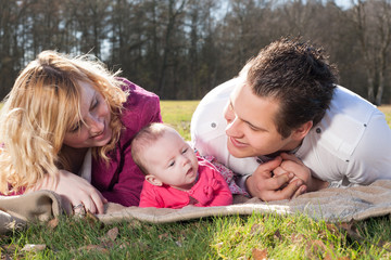 Young family on a blanket in the grass