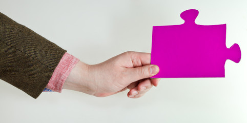 pink puzzle piece in male hand