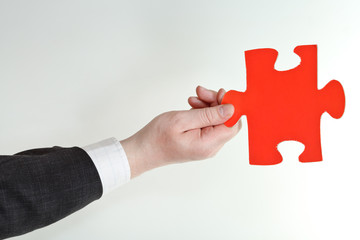 red puzzle piece in male hand