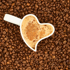 Filled cup on coffee beans