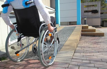 Fotobehang Frau im Rollstuhl auf Rollstuhlrampe © RioPatuca Images
