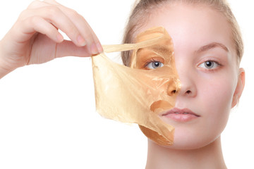 Girl woman in facial peel off mask. Skin care.