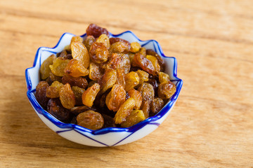 Diet healthy food. Raisin in bowl on wooden background
