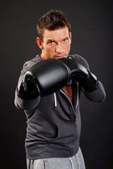 Fototapeta na wymiar Handsome muscular man boxes with boxer gloves