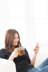 部屋でスマートフォンを見る女性