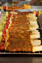 Chicken and beef shishkabobs laying on the grill being cooked.