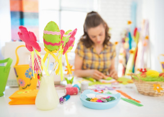 Closeup on threads and buttons on table and woman making egg