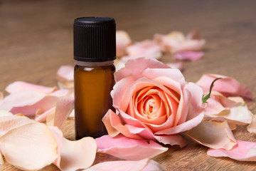 bottle with essential oil and rose petals