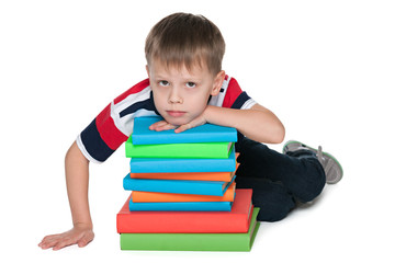 Sad little boy with books