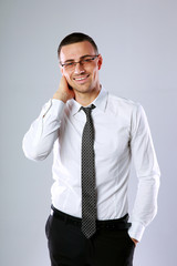 Portrait of a happy businessman on gray background