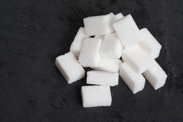 Morceaux de sucre en vrac sur fond d'ardoise