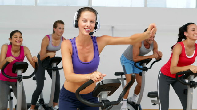 Spinning class in fitness studio led by energetic instructor
