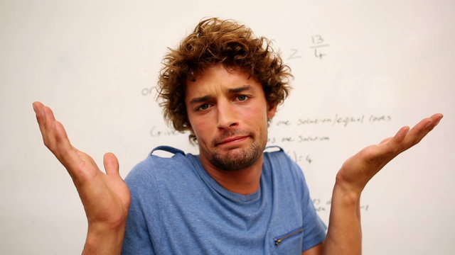 Confused student standing in front of whiteboard of math