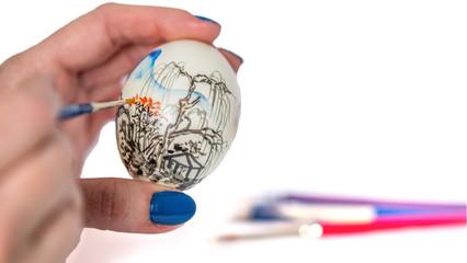 Female hands painting easter egg