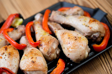 Close-up of grilled chicken legs with sliced bell pepper