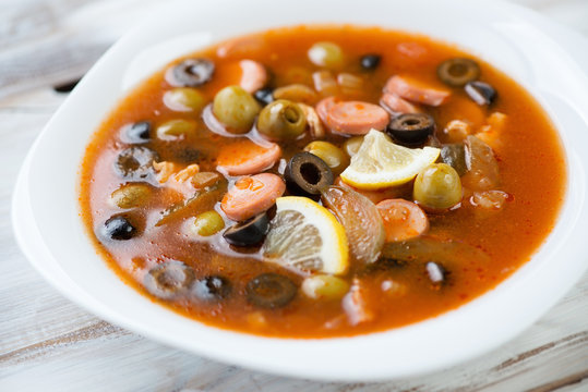 Close-up of russian solyanka soup with meat, sausages and olives