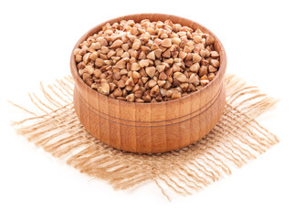 Buckwheat in the wooden bowl isolated on white background