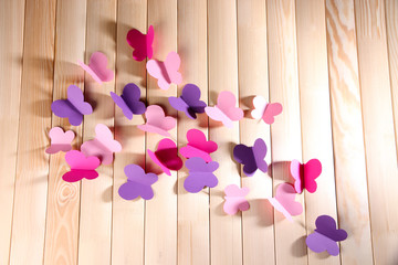 Paper cut out butterflies, on wooden background