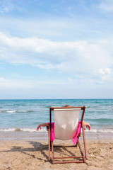Girl sitting on a chair on the beach