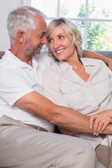 Mature couple looking at each other in living room