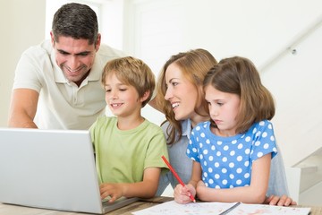 Family using laptop at table