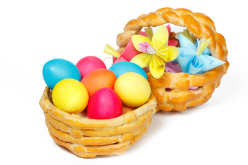 Fototapeta na wymiar Dwa pieczone kosz z Wielkanoc kolorowych jaj i papierowych kwiatów