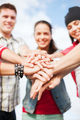 teenagers hands on top of each other outdoors
