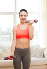smiling teenage girl exercising with dumbbells