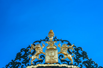 Fototapeta na wymiar Iron fence in garden with coat of arms