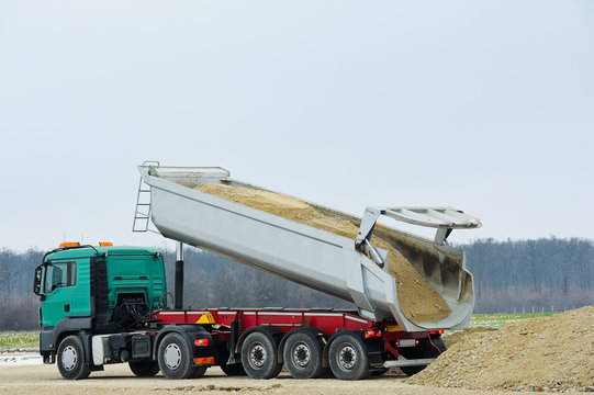 LKW mit Kipper l&auml;dt Erde ab