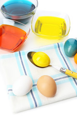 Bowls with paint for Easter eggs and eggs, isolated on white