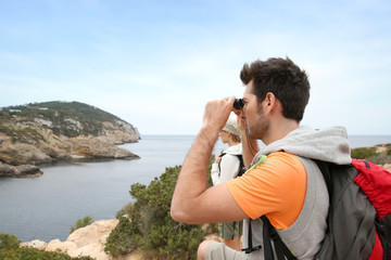 Man using binoculars on a hiking day