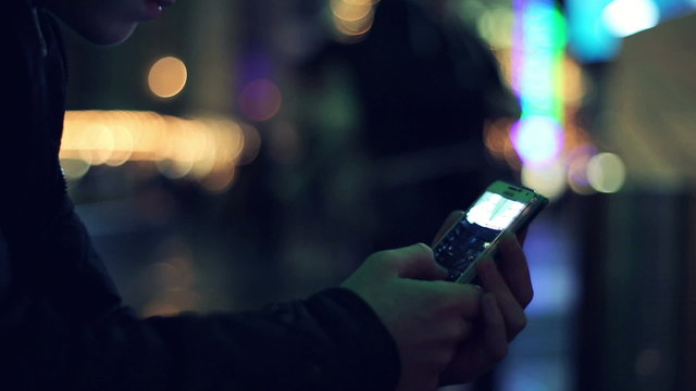 Young teenage boy watching photos on smartphone