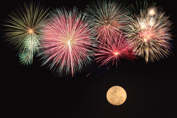 Colorful fireworks and full moon  over black background