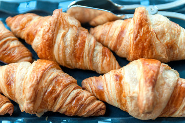 group of croissant laying on the blue tablecloth