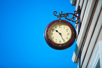 Fototapeta na wymiar Street clock on the background of blue sky