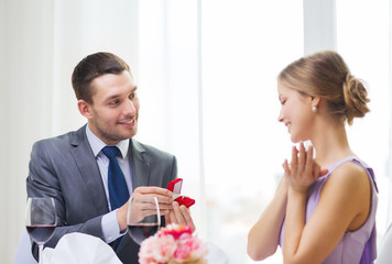 Obraz na płótnie Canvas man proposing to his girlfriend at restaurant