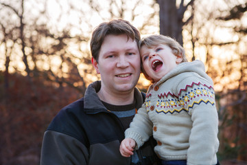 Father and little son in park or forest, outdoors.