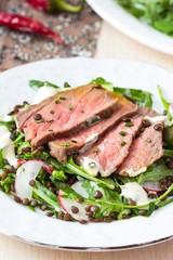 Salad with grilled beef steak, black lentils, rocket, radish