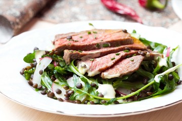 Salad with grilled beef steak, black lentils, rocket, radish