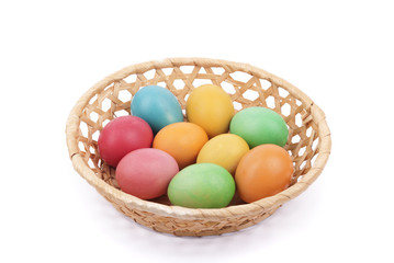 Easter painted eggs in a basket, isolated on white.