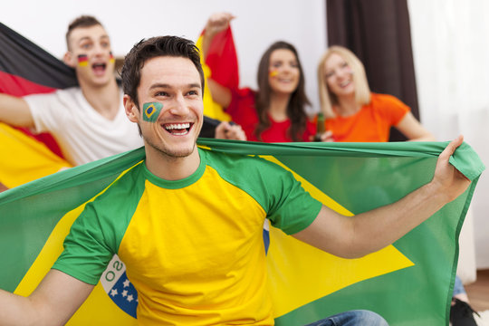 Brazilian man with friends enjoying the soccer on TV