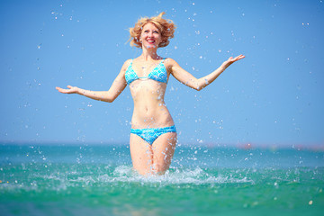 pretty girl jumping in sea water