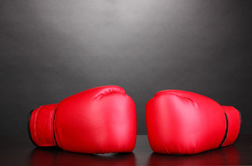 Red boxing gloves on grey background