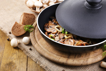Delicious fried mushrooms in pan on table close-up