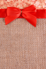 Sackcloth with color ribbon and bow on color paper background