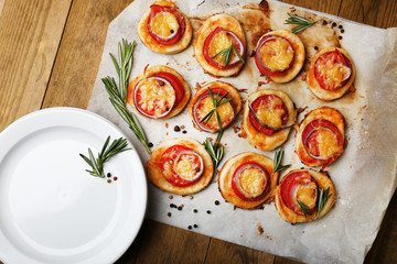 Small pizzas on baking paper close up