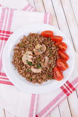 Boiled buckwheat on plate on table close-up