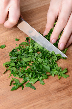 Chopped parsley on wooden board close-up