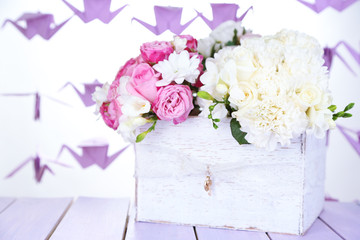 Beautiful wedding flowers in crate on table on bright